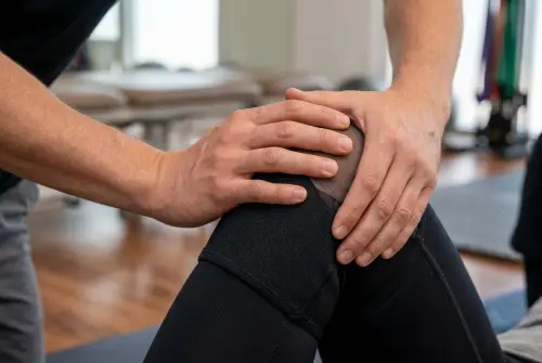 Physical therapist adjusting knee brace on patient's leg