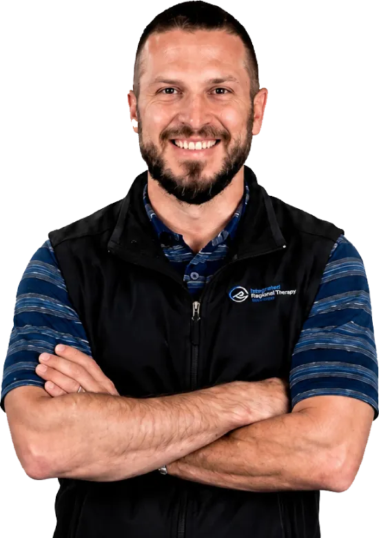 Smiling male team member with arms crossed, wearing a Regional Therapy vest